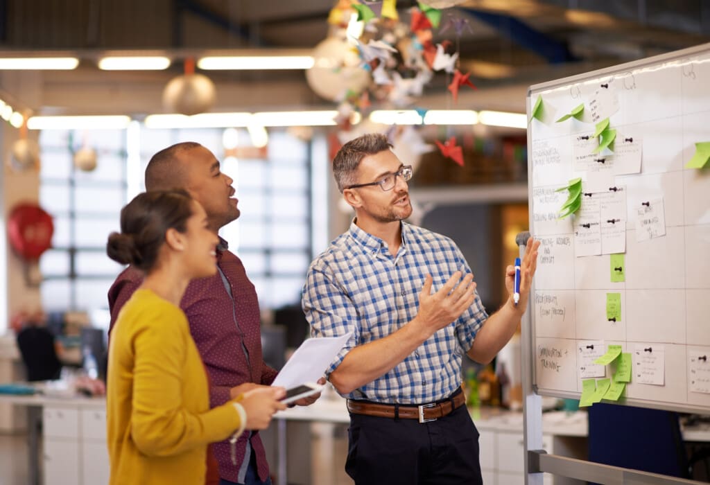 Whiteboard, manager plan and business people with strategy and speaking in a office. Startup, company training and creative writing group with communication and vision with ideas and seo report