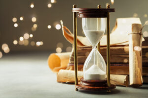 Sand running through the hourglass and old vintage books.