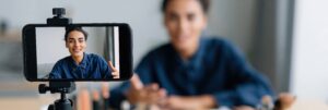 Woman recording a vlog with a smartphone on a tripod for social media content creation and online video banner